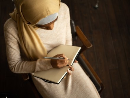 young woman writing in book 