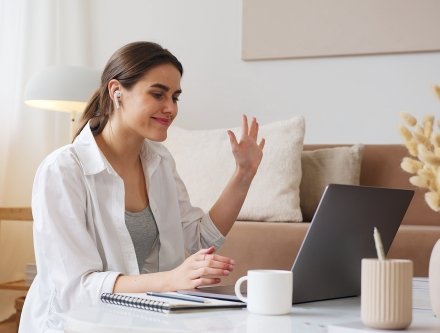woman waving at laptop