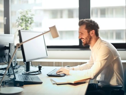 man smiling at computer in office