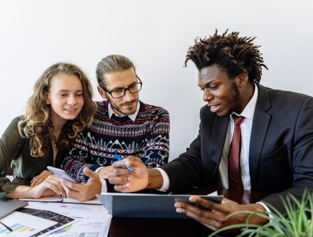 three people looking at computer 