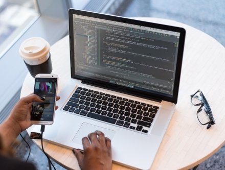 laptop and iphone with glasses on table