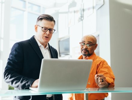 2 men staring at computer screen